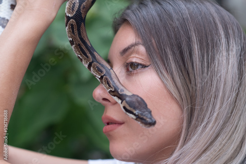 Sensual young woman portrait with a snake in nature