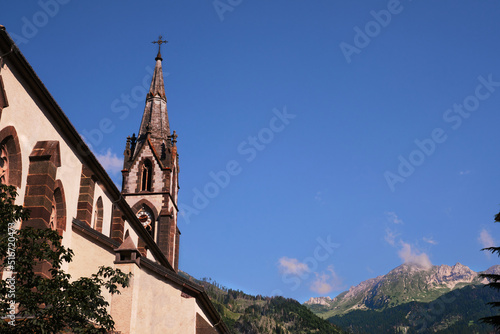 church of saints filippo and giacomo in the village of predazzo trentino alto adige with a mountain background photo