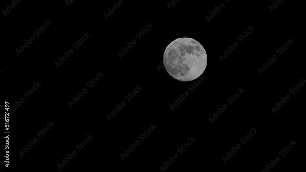 Full Moon On Dark Night, shines in the sky without clouds. Closeup shot of the Full moon moving across the sky Full Moon On Dark Night, shines in the sky without clouds. Closeup shot of the Full moon moving across the sky