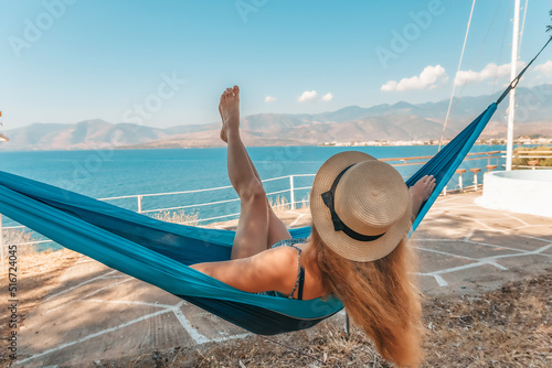Beautiful girl relaxing in a hammock near the sea
