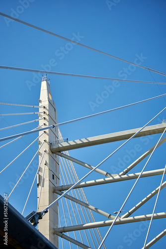 Ropes of a cable-stayed bridge against a blue sky