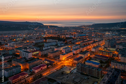 Beautiful morning aerial photograph of the northern city. Top view of the streets and buildings. Dawn. In the distance the sea and hills. City of Magadan, Magadan region, Siberia, Far East of Russia.