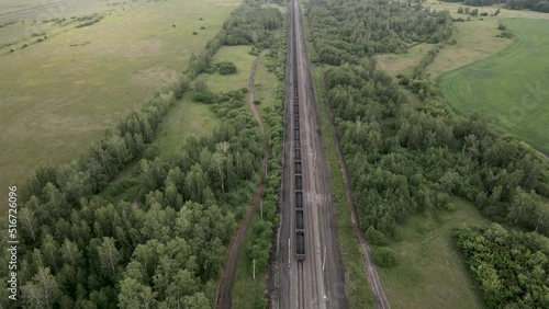 Coal train aerial view. An electric locomotive with freight cars or a railway carriage travels by rail.A train with coal is traveling by rail. railway train