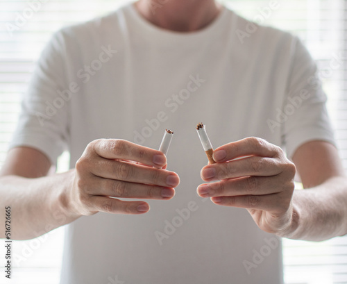 A broken cigarette in his hands. Quitting smoking. Smoking is harmful