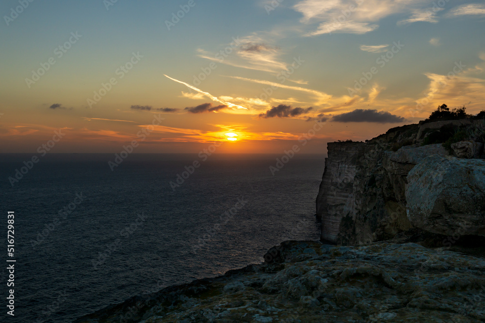 Cliffs in the foreground with the sea in the background at sunset with a colorful and beautiful sky.