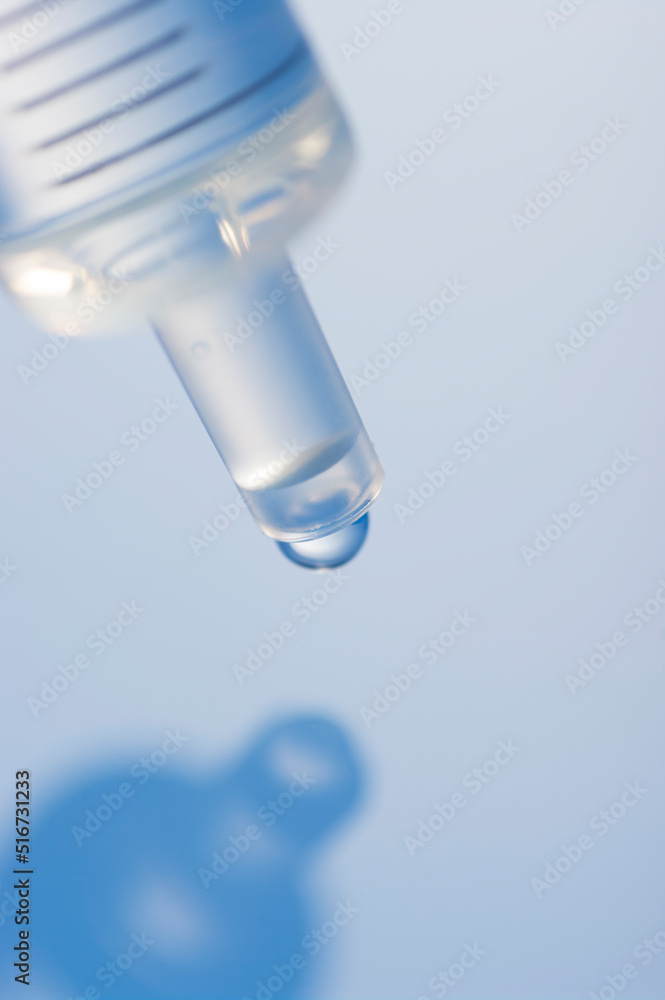 Macro image of a syringe with droplet. Syringe macro view in blue. Macro image of a syringe with droplet. Syringe macro view in blue.