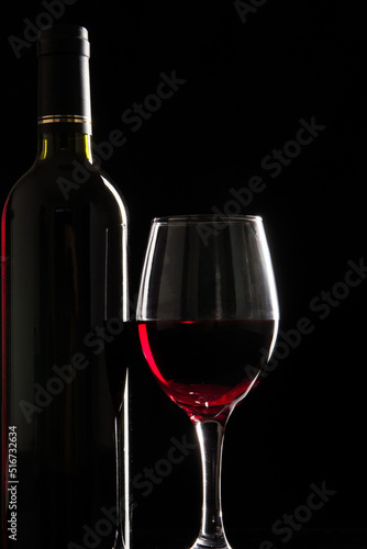 wine glass with red wine on black background