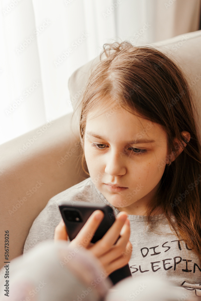 Teenager girl sitting alone on couch using smartphone. Teenager girl sitting alone on couch using smartphone.