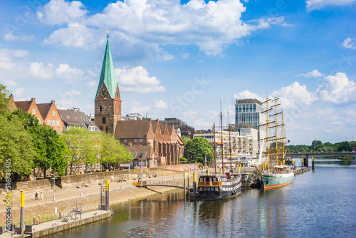 Fotografering Historic sailing ships and church tower at the Weser river in Bremen, Germany