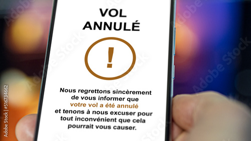 Un voyageur est informé sur son téléphone que son vol a été reporté. La compagnie aérienne annonce un vol annulé. 