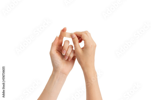 Young woman sticking plaster to injured place on her hand. Injury treatment, first aid concept.