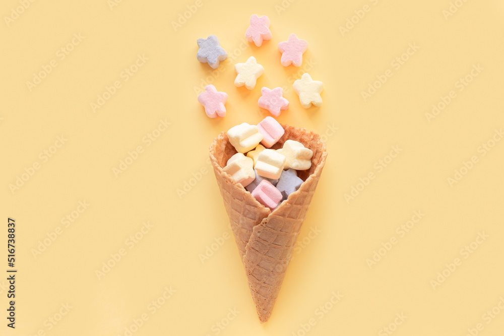 Ice cream waffle cone with marshmallows on pastel background Ice cream waffle cone with marshmallows on pastel background