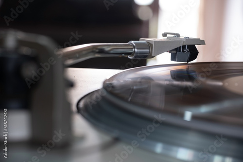 Focus on The Headshell Cartridge and Stylus of Classic Vintage Vinyl Record Player Playing on Vinyl Record Music