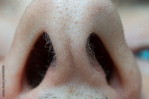 Caucasian male open nasal nostrils macro close up shot. Short nasal hairs, low angle view, unrecognizable face photo