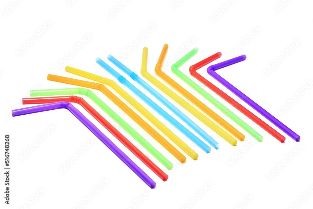 Blue, yellow, orange, green, red and blue drinking straws are placed on a white background. Take a photo from below