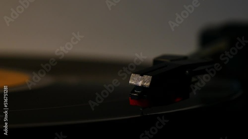 Stylus needle on vinyl record in low light, dark light conditions. photo