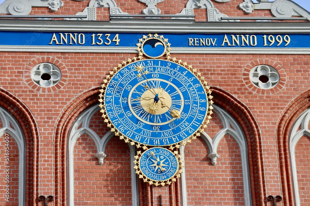 Decoration on the facade of Black Heads house in Riga, Latvia. Medieval astronomical calendar clock with blue dial and gold hands