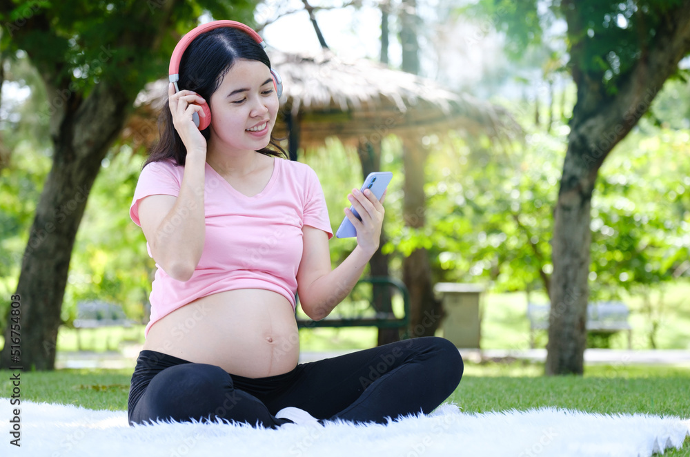 Asian pregnant woman relax in the park. Asian pregnant woman relax in the park.
