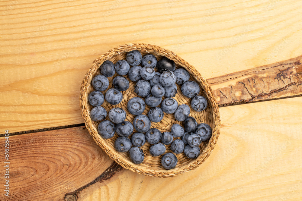 Organic blueberries with straw utensils, close-up, on a wooden table, top view. Organic blueberries with straw utensils, close-up, on a wooden table, top view.