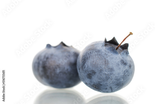 Two berries of organic ripe blueberries, close-up, on a white background.