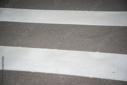 Pedestrian crossing on an empty asphalt city street, close-up.