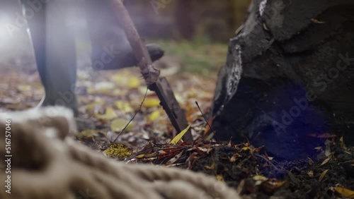 Man digging the soil near the rock