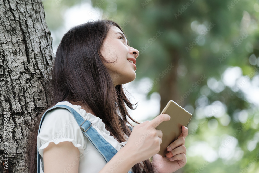 Young Asian teenage girl with tablet and notebook Young Asian teenage girl with tablet and notebook