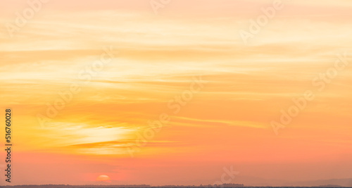 Sunset sky clouds in the evening with orange sunlight in golden hour natural background 