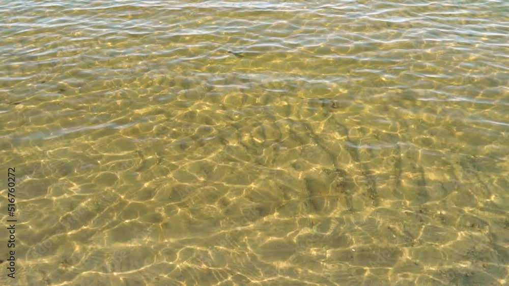 Reflections, glare and reflexes on the water surface on a sunny day.The sun's rays on the yellow golden sand under the water. Reflections, glare and reflexes on the water surface on a sunny day.The sun's rays on the yellow golden sand under the water.