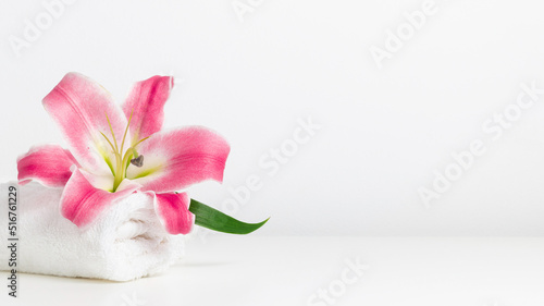 Fototapeta Naklejka Na Ścianę i Meble -  White towel and pink lily with copy space banner, spa minimal background
