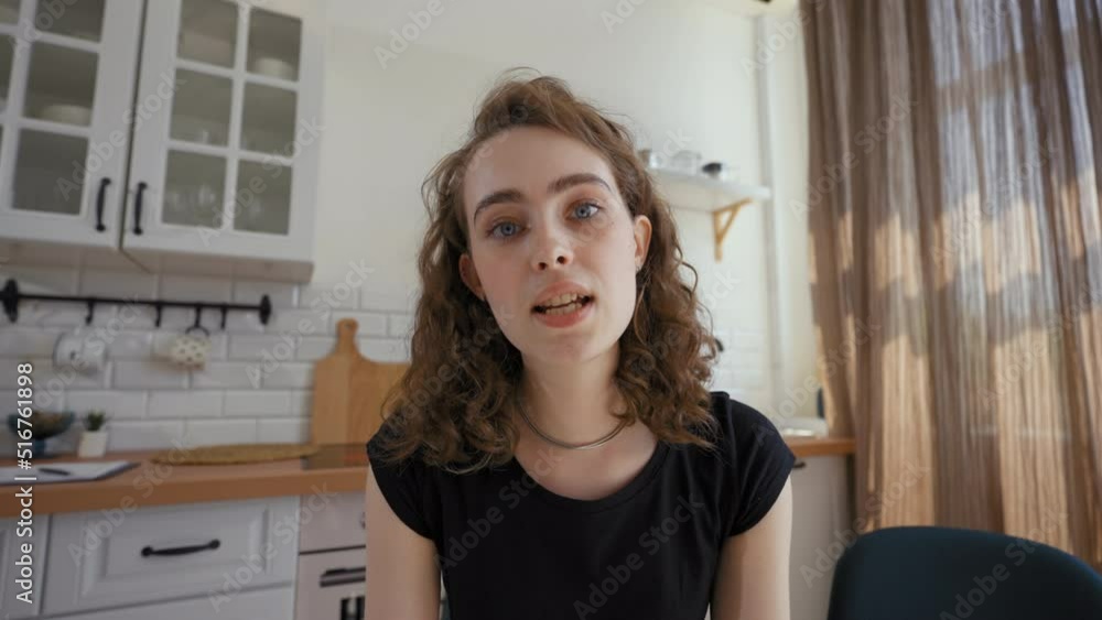 Cheerful woman talks to relative on video call distracted by boyfriend. Man comes into kitchen to hug girlfriend closeup from POV to third party Cheerful woman talks to relative on video call distracted by boyfriend. Man comes into kitchen to hug girlfriend closeup from POV to third party