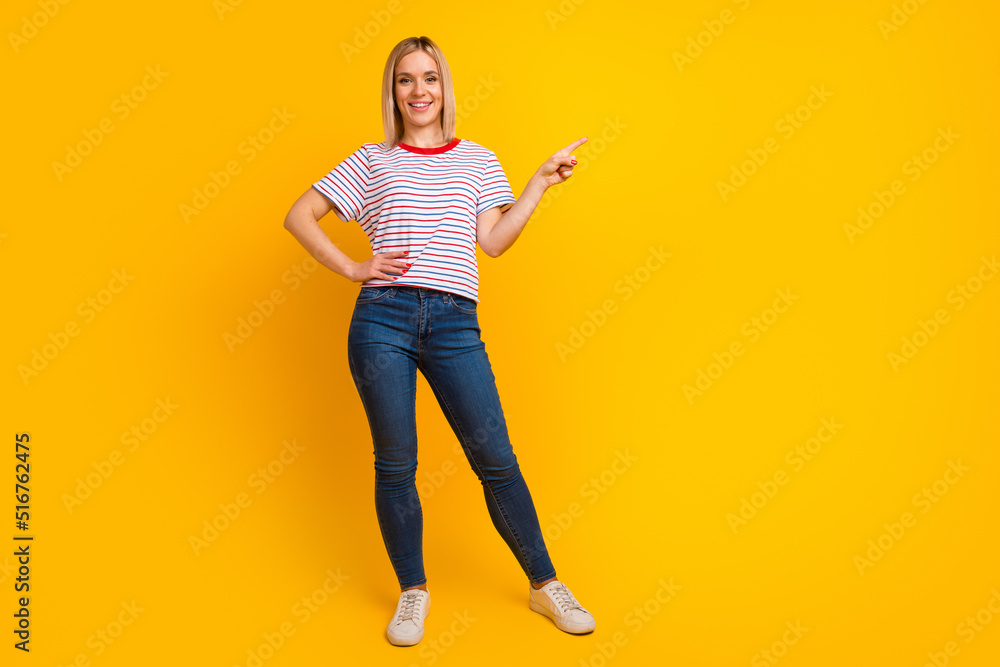 Photo of charming sweet young woman dressed shirt smiling pointing finger empty space isolated yellow color background Photo of charming sweet young woman dressed shirt smiling pointing finger empty space isolated yellow color background