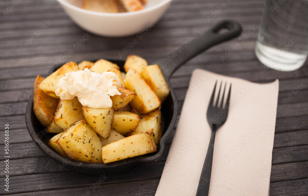 slices of fried potatoes with sauce on cast iron snack pa slices of fried potatoes with sauce on cast iron snack pa