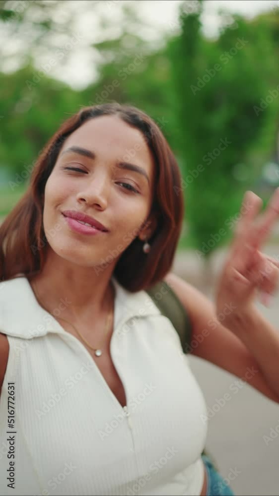 VERTICAL VIDEO: Clouse-up, lovely girl with brown long hair, tanned skin wearing white top is using mobile phone. Smiling young woman taking selfie on cellphone VERTICAL VIDEO: Clouse-up, lovely girl with brown long hair, tanned skin wearing white top is using mobile phone. Smiling young woman taking selfie on cellphone