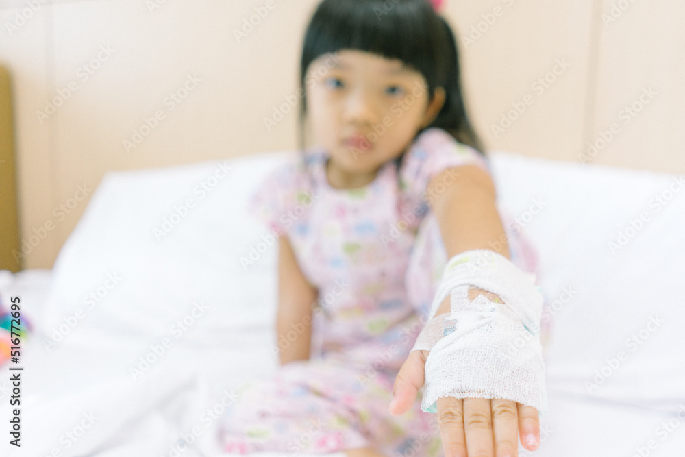 Asian child admitted in hospital with saline intravenous on hand. Focus on hand. Asian child admitted in hospital with saline intravenous on hand. Focus on hand.