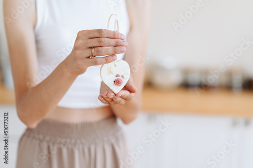 Photo Woman holds in her hands Florentine Sachet in Form of Heart with Gomphren Dried Flower