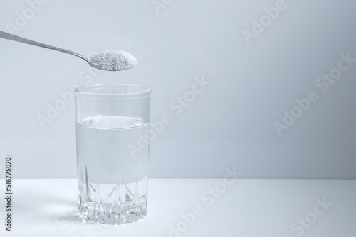 Biological food supplement. Dietary supplement for healthy sleep. Glass, spoon and dietary supplement powder. Modern still life. 