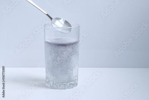 Biological food supplement. Dietary supplement for healthy sleep. Glass, spoon and dietary supplement powder. 