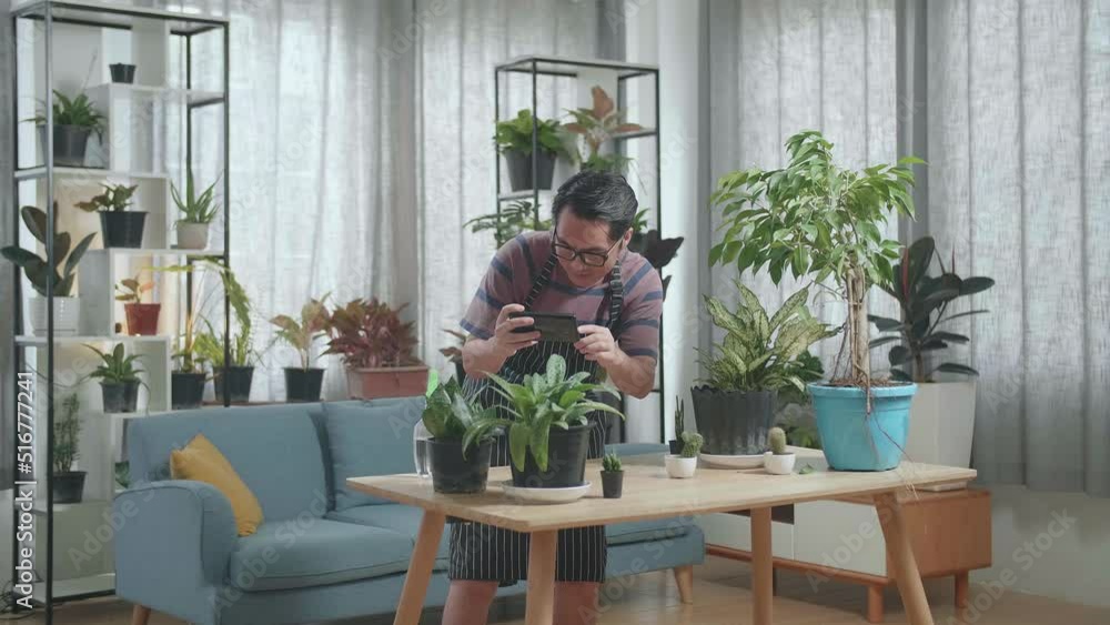 Asian Man Holding Smartphone And Taking Photos Of Plants At Home
Asian Man Holding Smartphone And Taking Photos Of Plants At Home