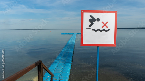 No Diving sign at beach, lake Naroch, Belarus. Warning sign of shallow water. Warning notice sign do not jump in water. photo