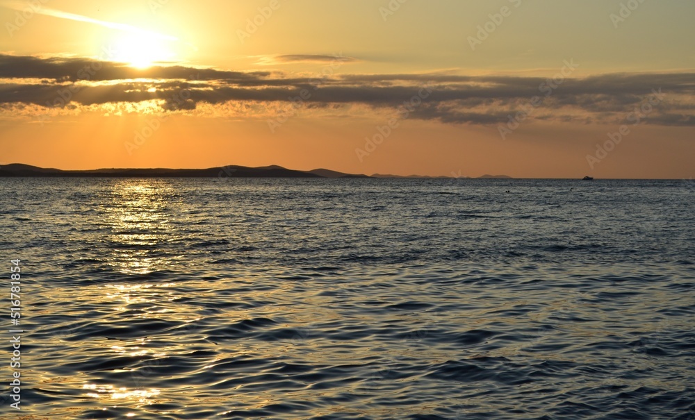 Sol de aterdecer cayendo detras de las montañas sobre el mar en Croacia Sol de aterdecer cayendo detras de las montañas sobre el mar en Croacia