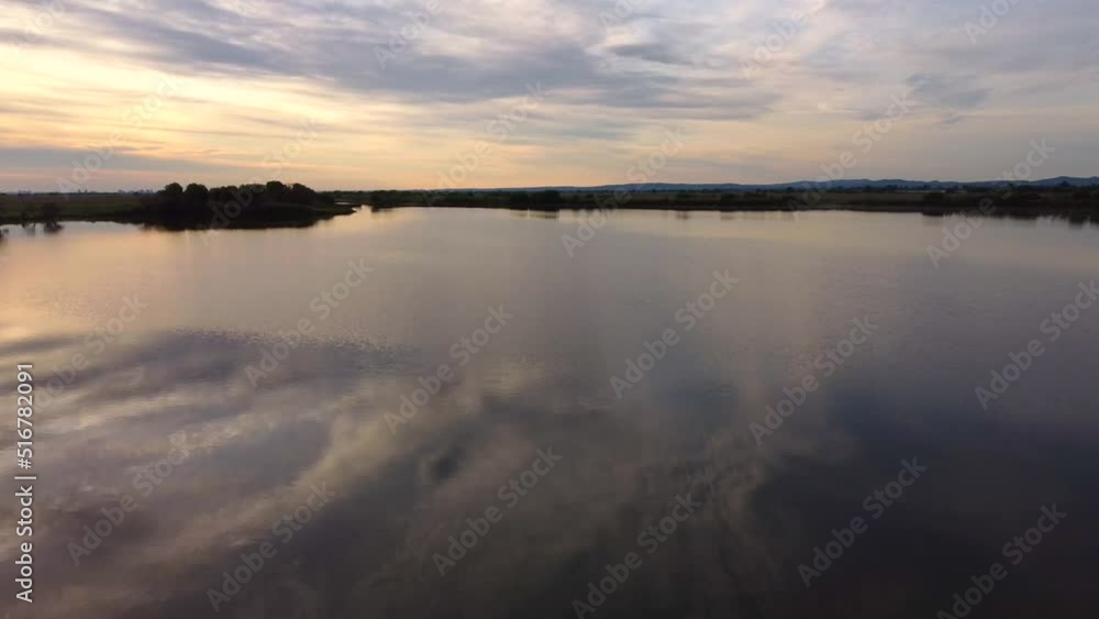Lake at dawn before sunrise. The drone is moving above the surface of the water. Bolshoy Ussuriysky Island in the Khabarovsk Territory in Russia. Lake at dawn before sunrise. The drone is moving above the surface of the water. Bolshoy Ussuriysky Island in the Khabarovsk Territory in Russia.