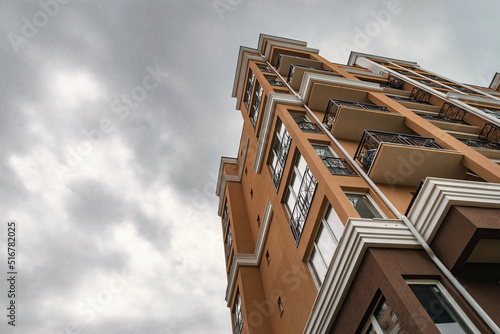 Valokuva A yellow multi-storey building against a blue cloudy sky