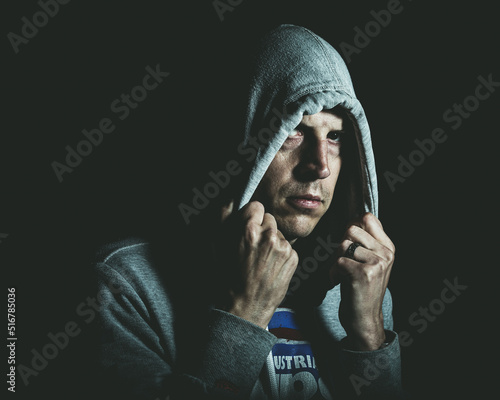 A man looks out from under a hoody