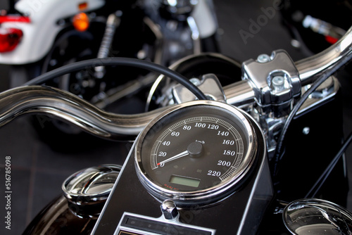 Speedometer and chrome parts on motorcycle handlebar in motorbike shop 