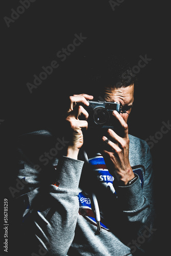 A man holds a vintage camera and takes photographs