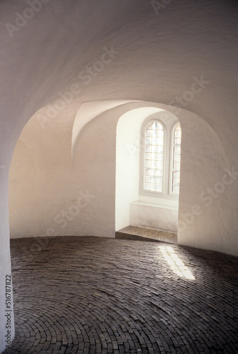 Covered slop with arched ceiling and mullioned windows photo