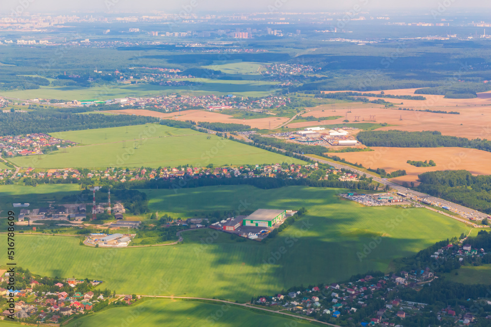 aerial view of fields, houses buildings or small city on beautiful summer day with green landscape