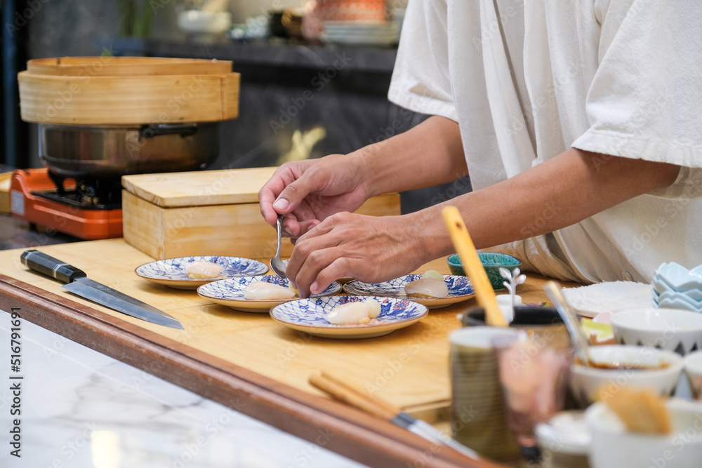 Professional and experienced sushi chef preparing sushi with confident and dedication to his perfect sushi.