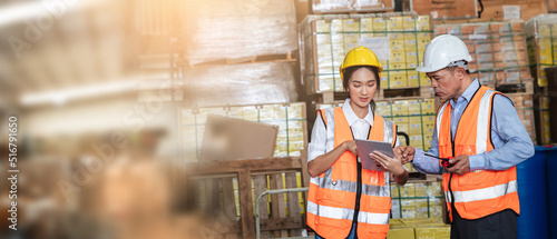 Asian engineer and forewoman checking details work on a tablet in the background warehouse.